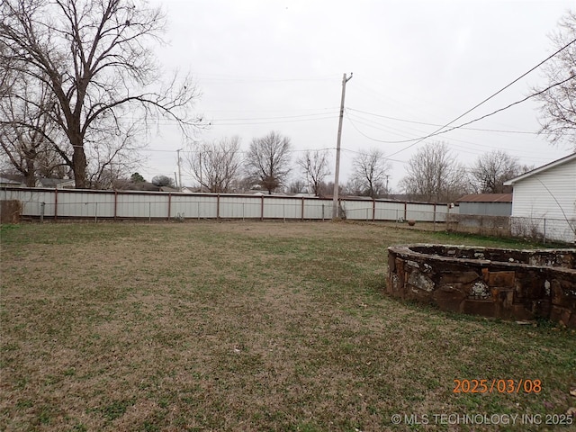 view of yard featuring a fire pit and a fenced backyard