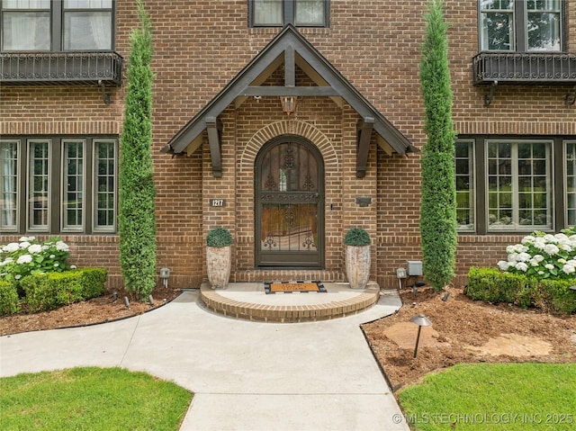 doorway to property featuring brick siding