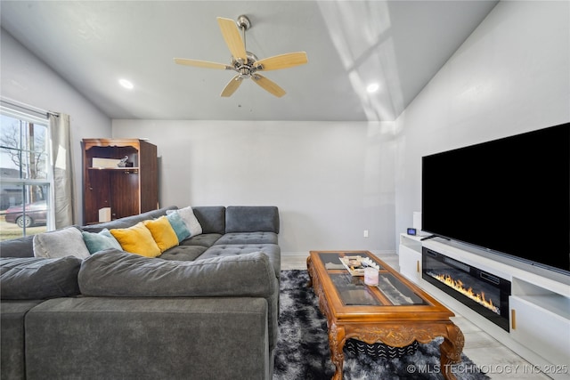 living room with lofted ceiling, recessed lighting, a glass covered fireplace, ceiling fan, and baseboards