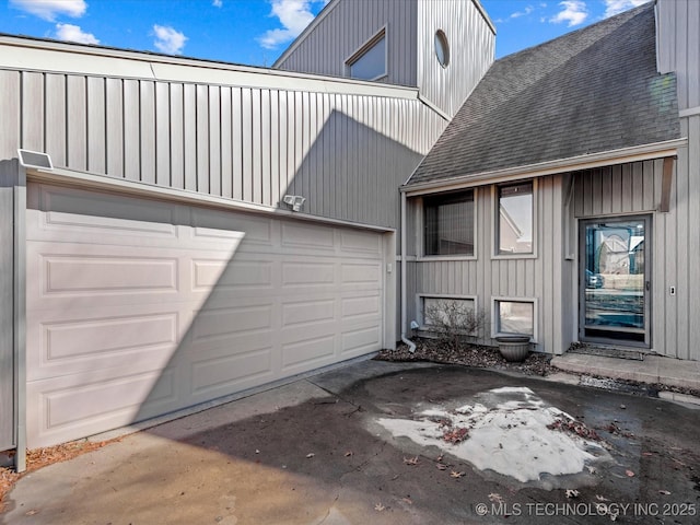 view of property exterior featuring concrete driveway and roof with shingles