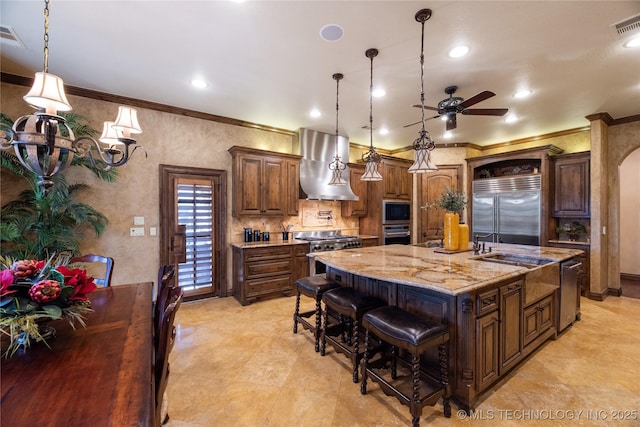 kitchen featuring crown molding, a large island, ventilation hood, and built in appliances