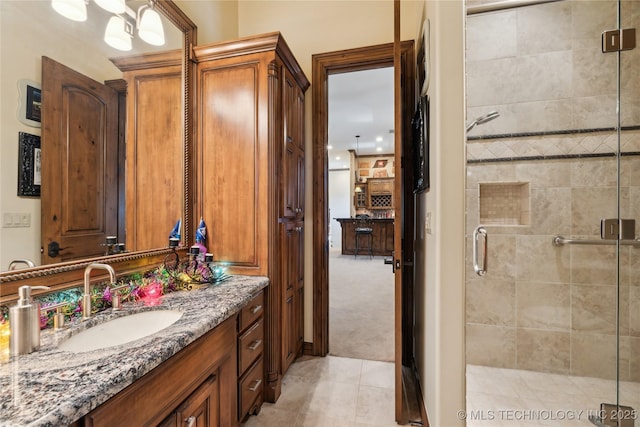 full bathroom with a shower stall, vanity, and tile patterned floors