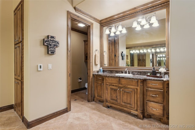 bathroom featuring baseboards, crown molding, vanity, and toilet