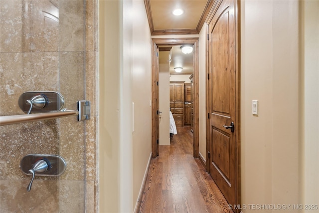 hall with baseboards, wood finished floors, and crown molding