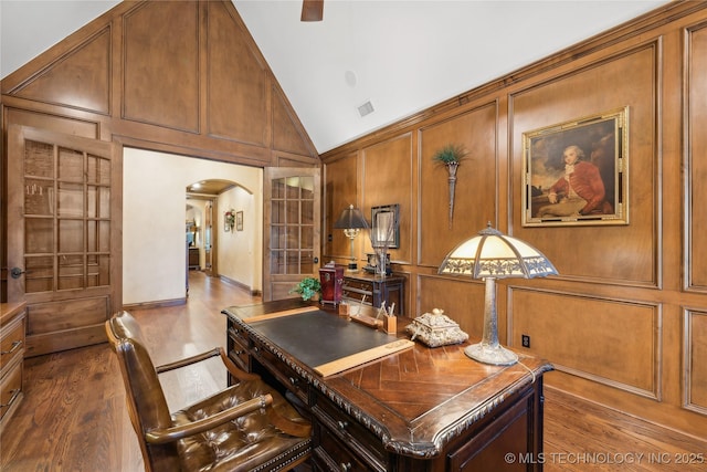 office space featuring arched walkways, dark wood finished floors, visible vents, and a decorative wall