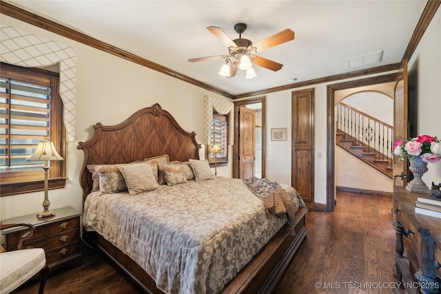 bedroom featuring baseboards, visible vents, a ceiling fan, dark wood-style floors, and crown molding