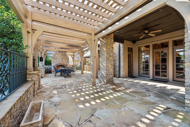 view of patio with ceiling fan, outdoor dining space, an outdoor stone fireplace, and a pergola