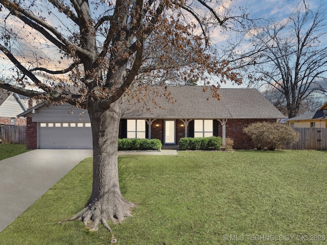 ranch-style home featuring a front yard, fence, brick siding, and driveway