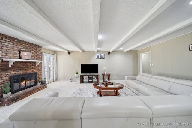 living room featuring beam ceiling, carpet flooring, a fireplace, and a textured ceiling