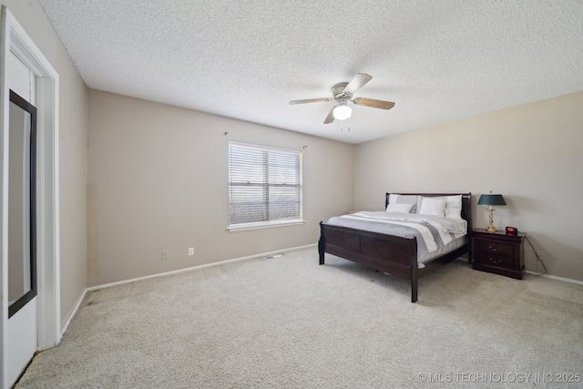 carpeted bedroom featuring baseboards, a textured ceiling, and ceiling fan