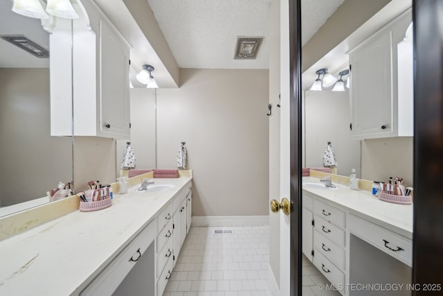 full bathroom with tile patterned floors, visible vents, a textured ceiling, and vanity