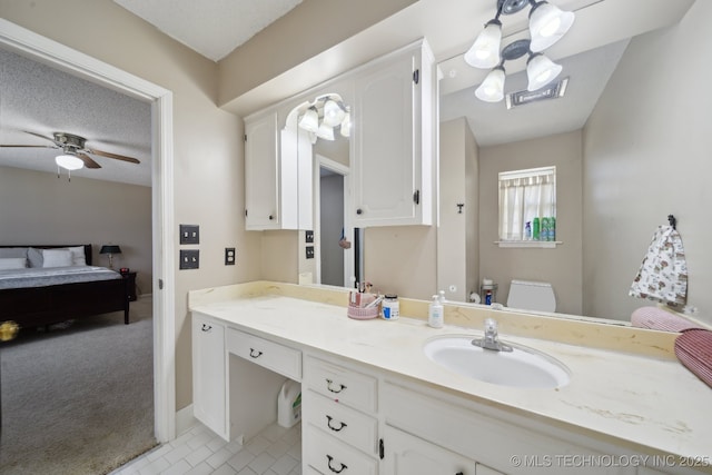 bathroom with toilet, a ceiling fan, ensuite bathroom, a textured ceiling, and vanity