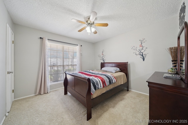 carpeted bedroom featuring baseboards, a textured ceiling, and a ceiling fan