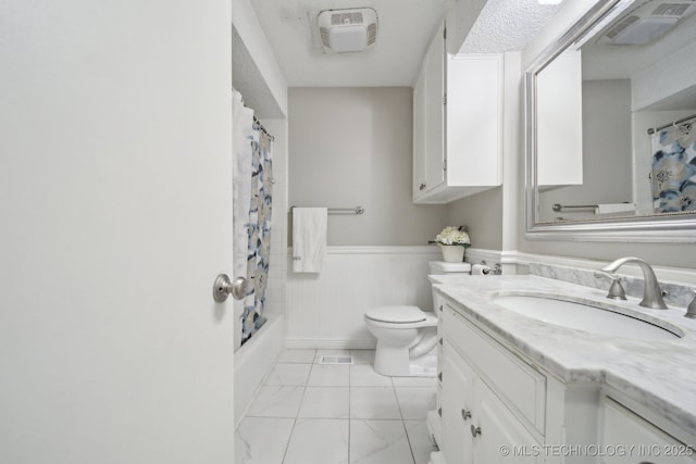 bathroom with visible vents, toilet, marble finish floor, wainscoting, and vanity