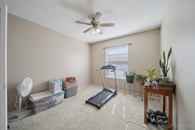 exercise room featuring ceiling fan, baseboards, carpet floors, and a textured ceiling