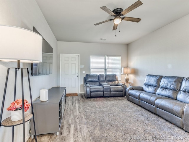 living room featuring visible vents, ceiling fan, and wood finished floors