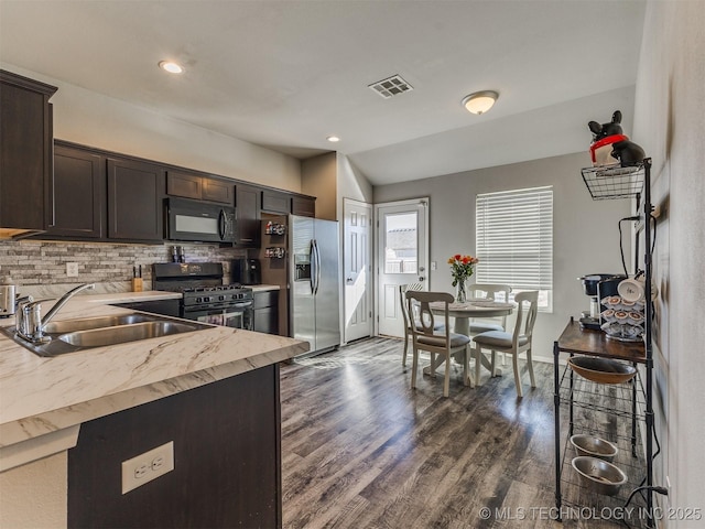 kitchen with dark brown cabinetry, visible vents, dark wood-style floors, black appliances, and a sink