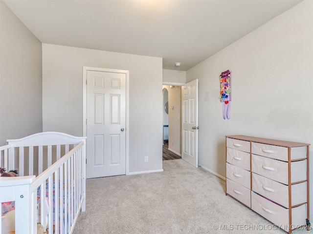 bedroom featuring arched walkways, carpet, and baseboards