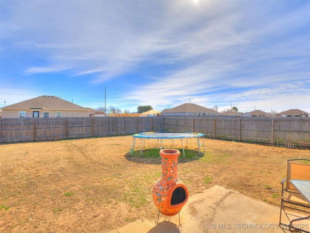 view of yard with a trampoline and a fenced backyard