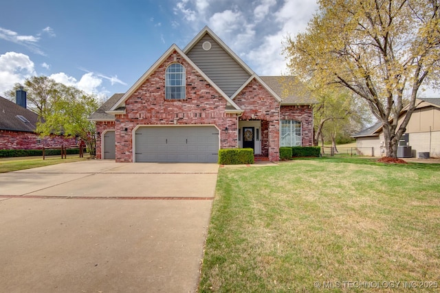 traditional-style house featuring brick siding, concrete driveway, an attached garage, fence, and a front yard