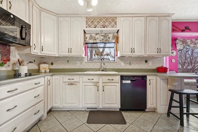 kitchen with light countertops, visible vents, light tile patterned flooring, a sink, and black appliances