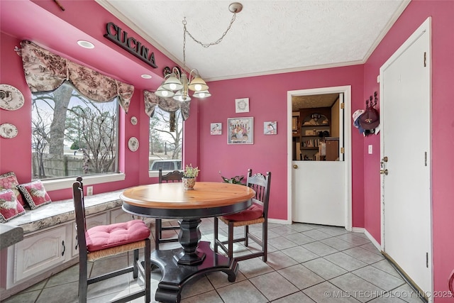 dining room with light tile patterned floors, a textured ceiling, a chandelier, baseboards, and ornamental molding