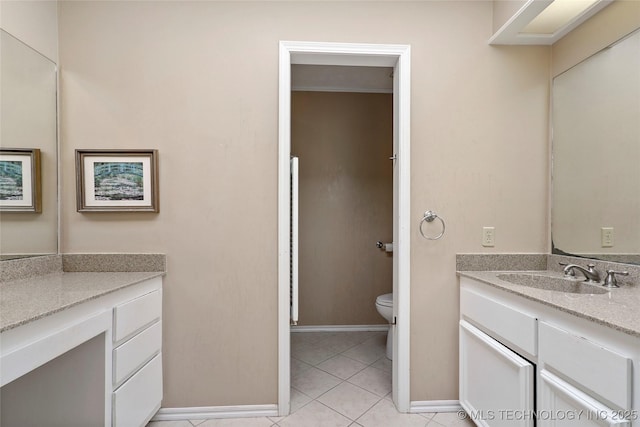 bathroom featuring toilet, tile patterned floors, baseboards, and vanity