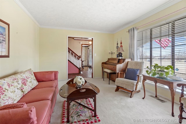 living room with a textured ceiling, carpet flooring, stairs, and crown molding