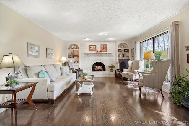 living area with built in features, a fireplace, a textured ceiling, and wood finished floors