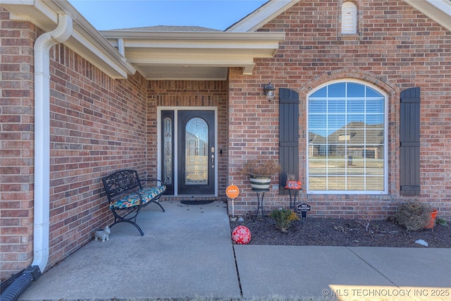 property entrance featuring brick siding