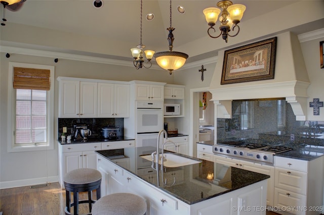 kitchen featuring a chandelier, dark wood-style floors, white appliances, white cabinetry, and a sink