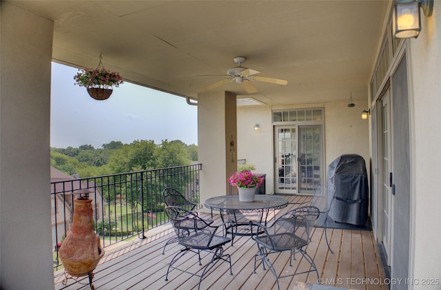 wooden terrace with a ceiling fan and grilling area