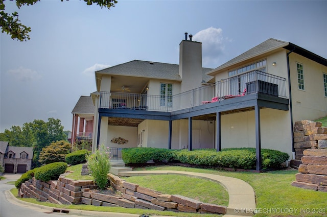 back of house featuring stucco siding, a chimney, and a ceiling fan