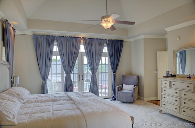 bedroom with access to exterior, a raised ceiling, baseboards, and ornamental molding