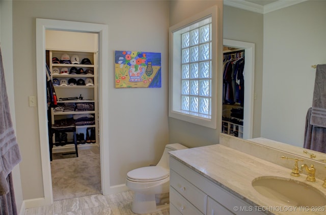 bathroom with a wealth of natural light, toilet, vanity, and ornamental molding