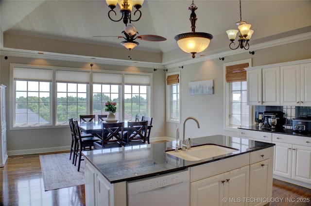 kitchen featuring a center island with sink, dishwasher, ornamental molding, ceiling fan with notable chandelier, and a sink