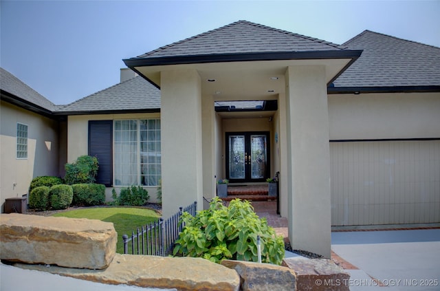 doorway to property featuring french doors, stucco siding, and a shingled roof