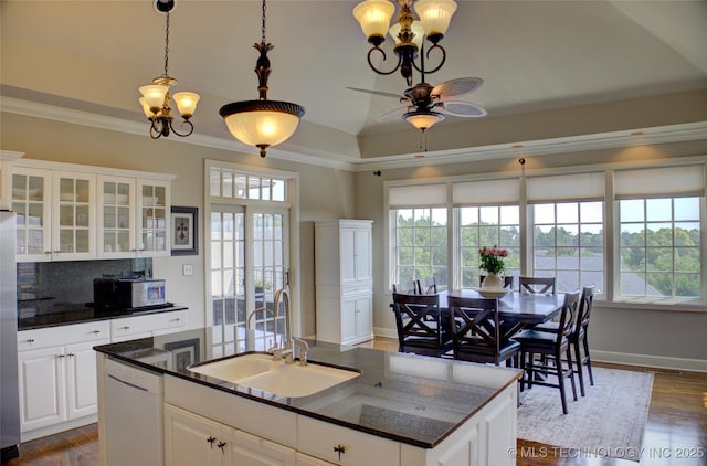 kitchen with white dishwasher, a sink, crown molding, ceiling fan with notable chandelier, and tasteful backsplash