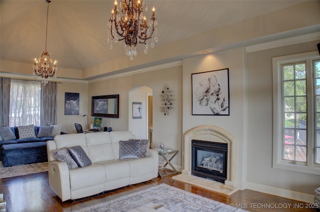 living area with a glass covered fireplace, wood finished floors, arched walkways, lofted ceiling, and a chandelier