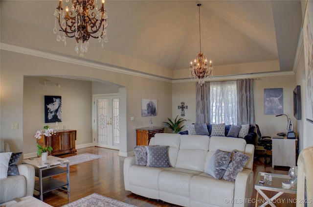 living area featuring lofted ceiling, a tray ceiling, an inviting chandelier, wood finished floors, and arched walkways