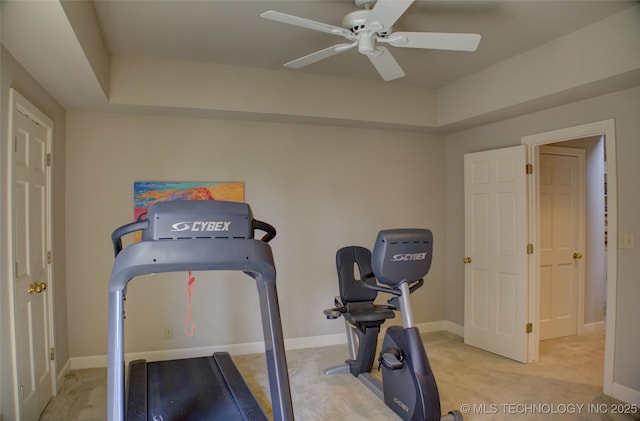 workout room featuring baseboards and ceiling fan