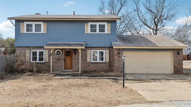 traditional-style home with a garage, concrete driveway, brick siding, and fence