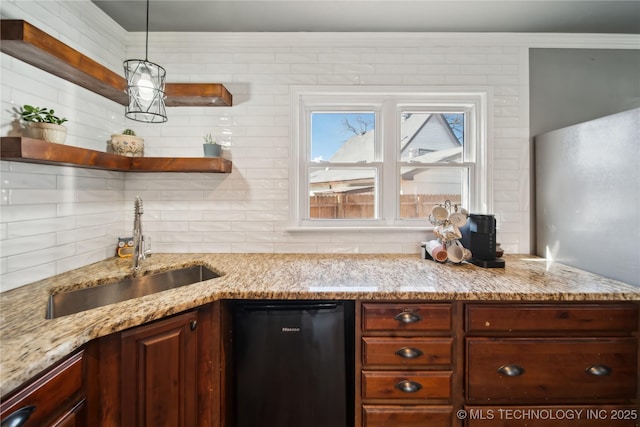 kitchen with black dishwasher, open shelves, backsplash, a sink, and light stone countertops