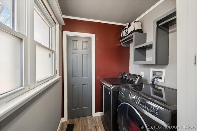 laundry area with visible vents, ornamental molding, separate washer and dryer, wood finished floors, and laundry area