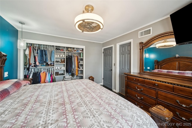 bedroom with a closet, visible vents, and crown molding