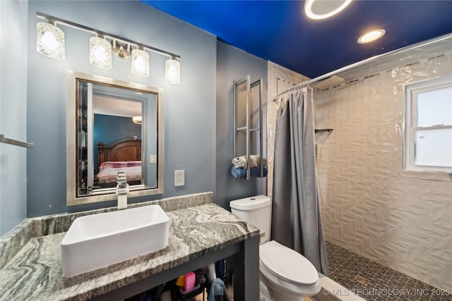 full bath featuring connected bathroom, a tile shower, toilet, and vanity