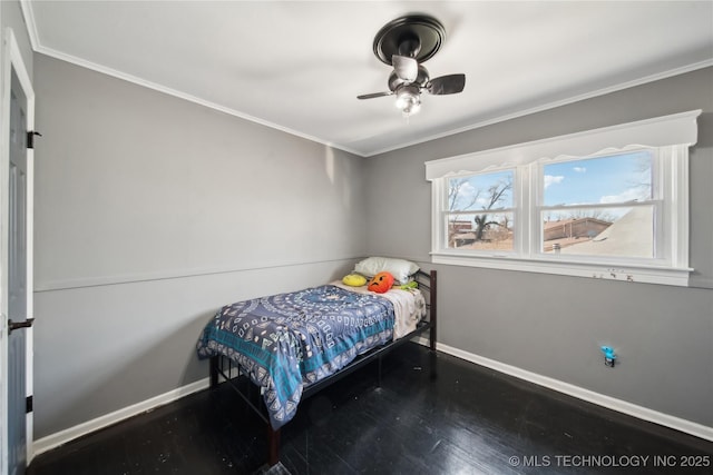 bedroom with a ceiling fan, crown molding, baseboards, and wood finished floors