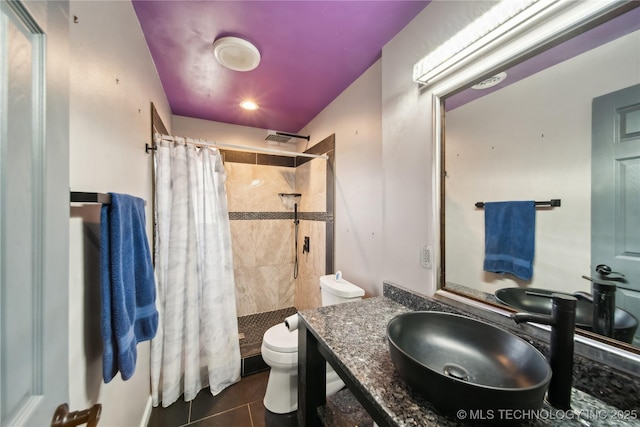 bathroom featuring toilet, tile patterned flooring, tiled shower, and vanity