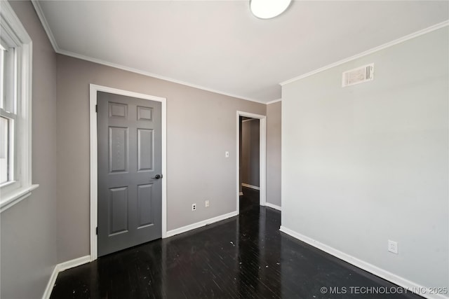 unfurnished bedroom with wood finished floors, visible vents, and baseboards