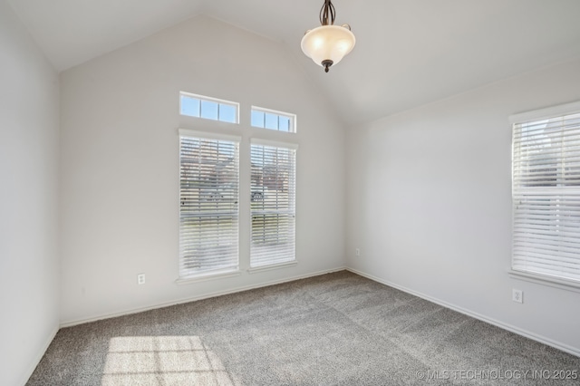 carpeted spare room with vaulted ceiling